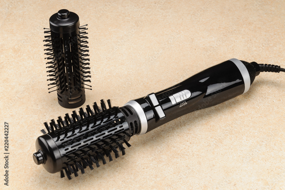Black brush hair dryer on the marble background with accessory Black brush hair dryer on the marble background with accessory