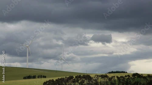 Wind turbines in green field with cloudy sky