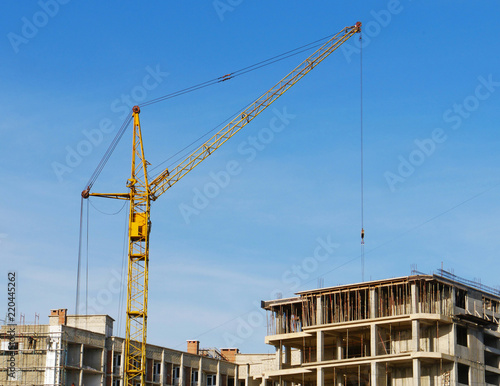  Construction site. Crane near building. Concrete building under construction.