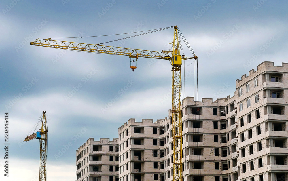 Two cranes and concrete building. Construction site background. Two cranes and concrete building. Construction site background.