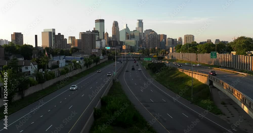 Downtown Minneapolis, MN at sundown. Traffic on the freeway speeds by in the foreground. Downtown Minneapolis, MN at sundown. Traffic on the freeway speeds by in the foreground.