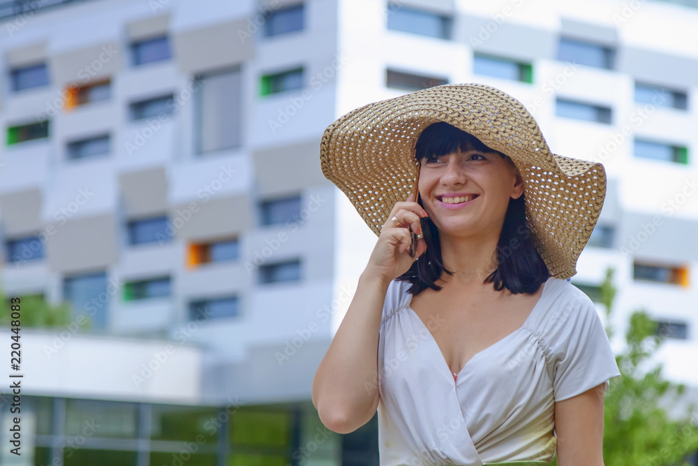 Portrait of young happy smiling businesswoman with smartphone outdoors as symbol of good news, freelance, success and wealth
