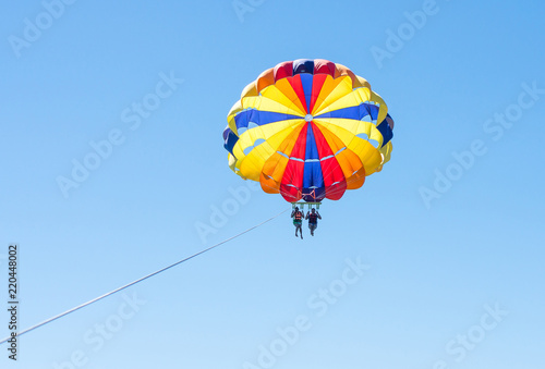 Happy couple Parasailing in Dominicana beach in summer. Couple under parachute hanging mid air. Having fun. Tropical Paradise. Positive human emotions, feelings, family, children, travel, vacation. 