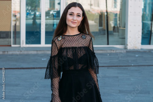 Emotional portrait of Fashion stylish portrait of pretty young woman. city portrait. sad girl. brunette in a black dress. expectation. dreams