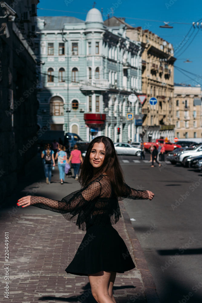 beautiful brunette whirls , dances on a street in the middle of the city, laughs, smiles, happiness,fun