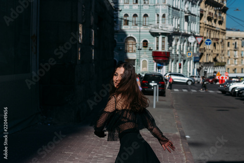 beautiful brunette whirls on a street in the middle of the city, laughs, smiles, happiness, fun © Skripnik Olga