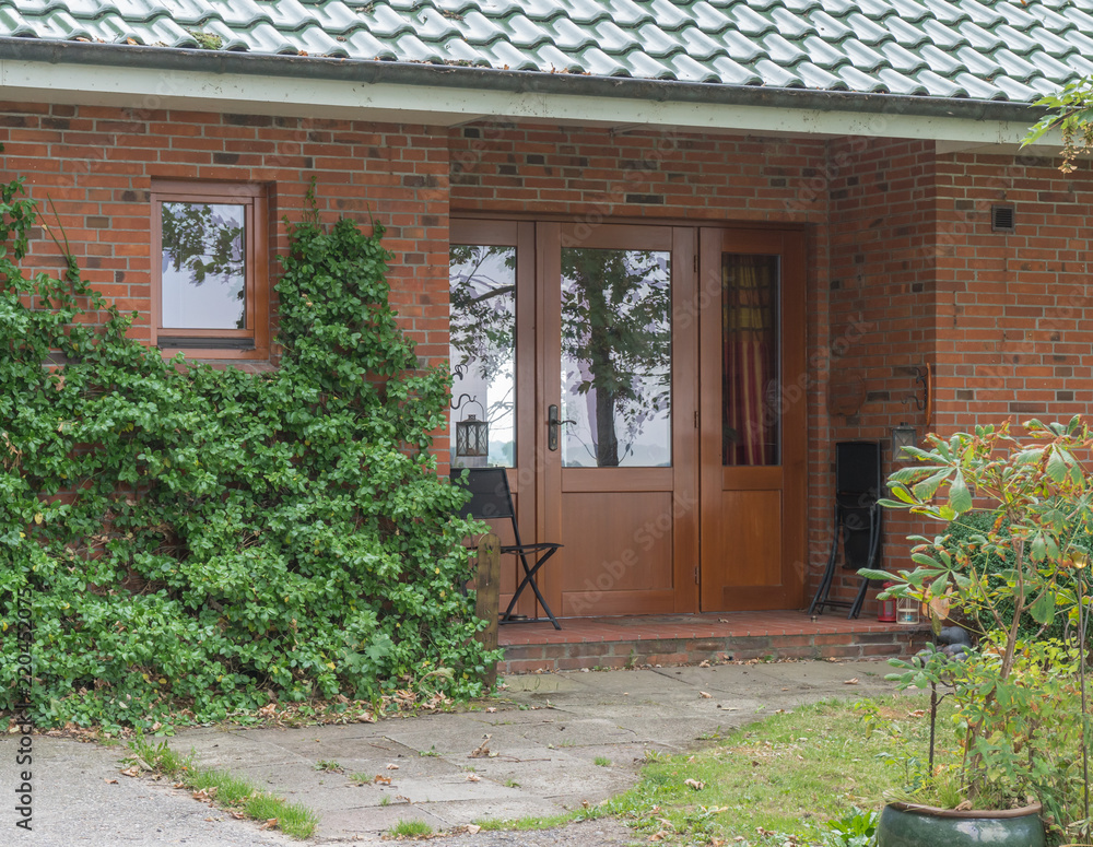 Fototapeta premium Große braune Haustür aus Holz mit Glaselement