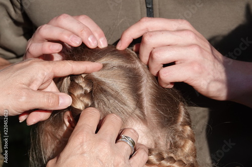 Checking a young girls hair for head lice © mjowra