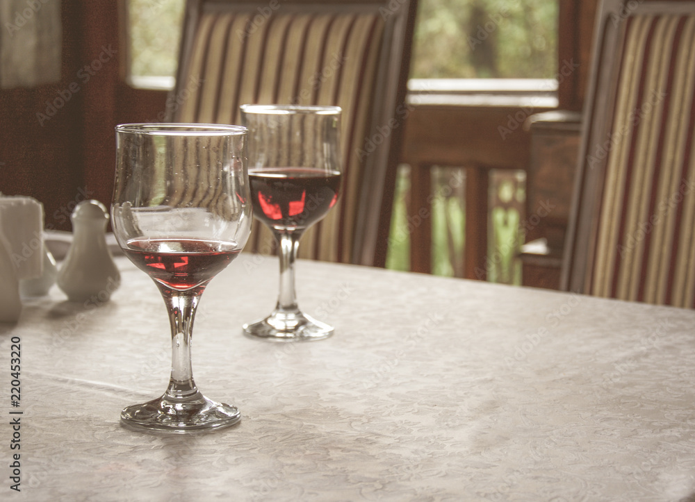 red wine in wine glasses on the table covered with white tablecloth red wine in wine glasses on the table covered with white tablecloth