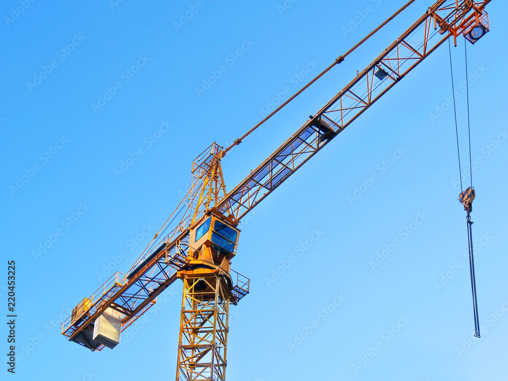 Self-erection crane against blue sky.