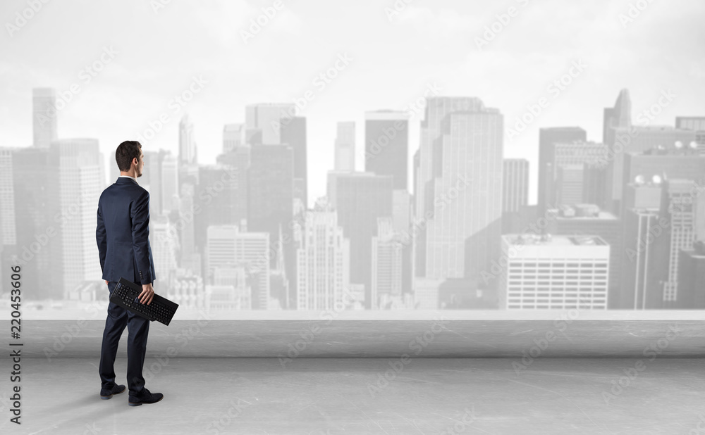 Businessman standing with his back on a roof with objects in his hand
Businessman standing with his back on a roof with objects in his hand