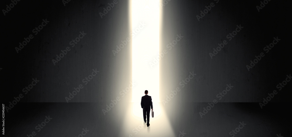 Businessman standing and seeing the light at the end of a big wall
Businessman standing and seeing the light at the end of a big wall