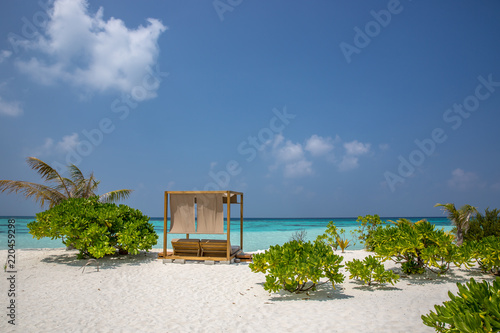 Amazing beach, yellow beach umbrella, blue sky, concept of paradise, perfect gateway vacation. © LMspencer