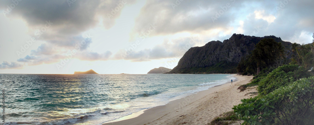 Naklejka premium Early Morning Sunrise on Waimanalo Beach over Rock Island bursting through the clouds