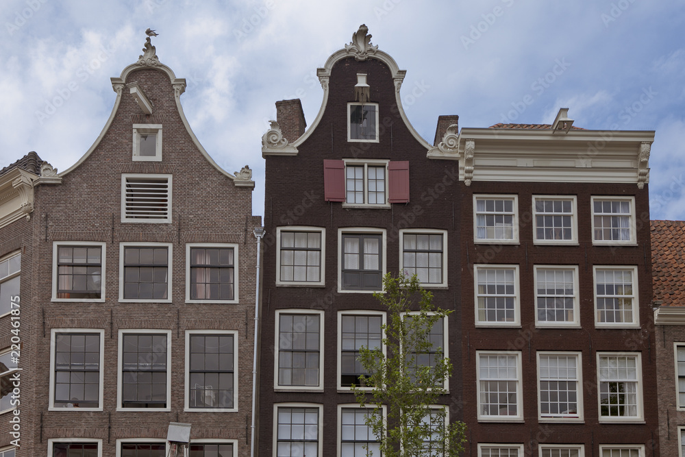 Facades of typical canal houses in Amsterdam, popular with tourists for the authentic historic architecture and specific atmosphere and beauty