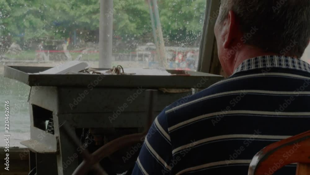 old chinese man at work steering boat in traditional fishing village crossing river at old city guilin china old chinese man at work steering boat in traditional fishing village crossing river at old city guilin china