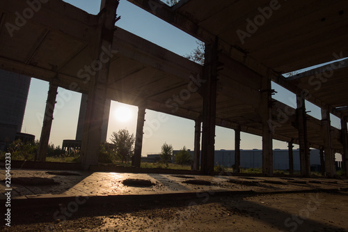 A deserted industrial plant site with old deserted structure on a beautiful sunset.