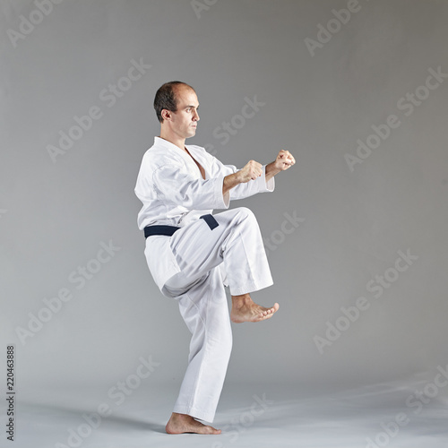 Sportsman in karategi and with a black belt trains formal karate exercises