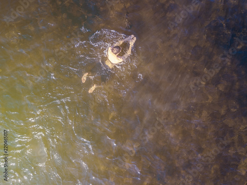 aerial top view of man enjoying swim in heaven ocean lagoon background