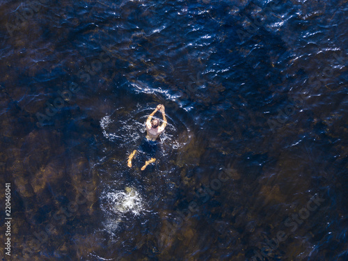 aerial top view of man enjoying swim in heaven ocean lagoon background