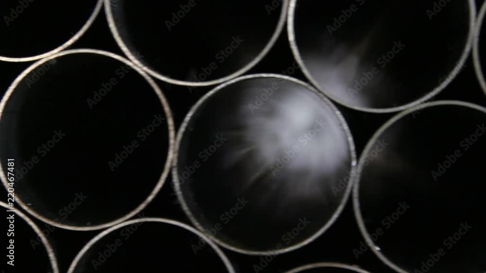 Reflection of light when shooting in defocus of shiny metal tube in factory. Welded profile pipes are made of alloy steel. Rolled metal product manufacturing. Reflection of light when shooting in defocus of shiny metal tube in factory. Welded profile pipes are made of alloy steel. Rolled metal product manufacturing.