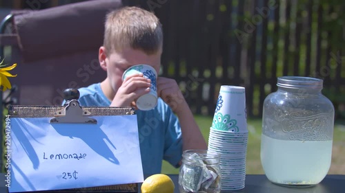Bored Boy Drinking and Selling Lemonade