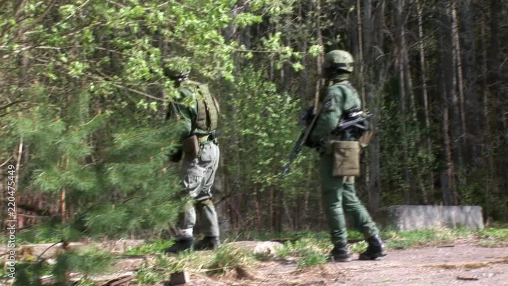 Players of airsoft in military uniform with a weapon on background of forest. Sports game using a copy of a firearm. Players of airsoft in military uniform with a weapon on background of forest. Sports game using a copy of a firearm.