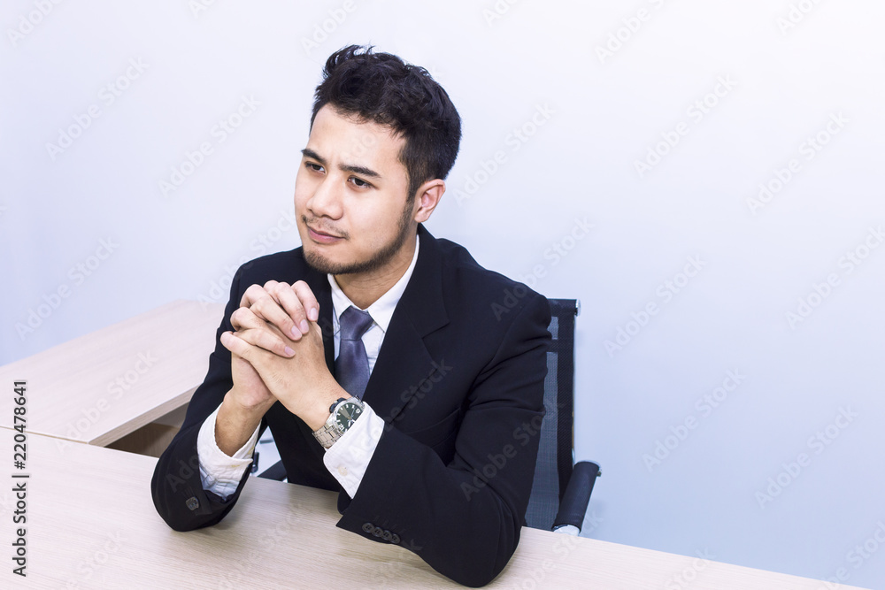 Young handsome businessman smiling and thinking at office .Copy space. Young handsome businessman smiling and thinking at office .Copy space.