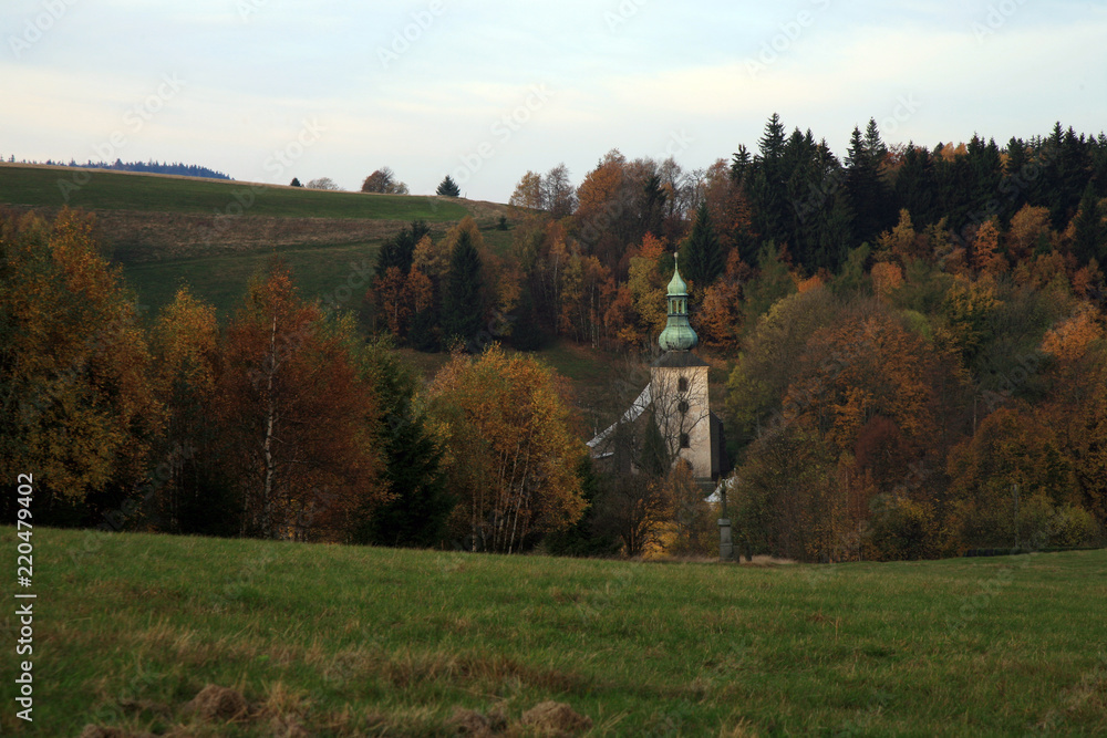 Tower of the baroque church among the hills. Pasterka, a small village in the Table Mountains in Poland, the destination of holiday travels of mountain lovers.