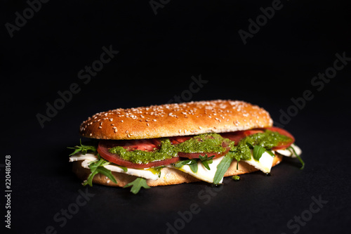 Panini, burger with sesame bun on a dark background