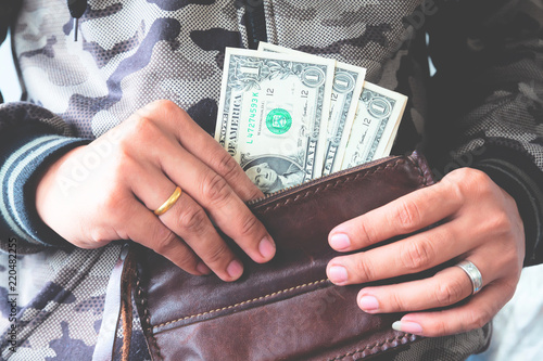 Man hands holding US dollar bills in leather wallet, Freelance. Saving money