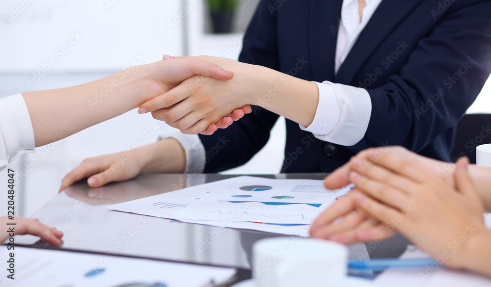 Group of business people shaking hands while finishing up a meeting. Handshaking, agreement or success concept in communication Group of business people shaking hands while finishing up a meeting. Handshaking, agreement or success concept in communication