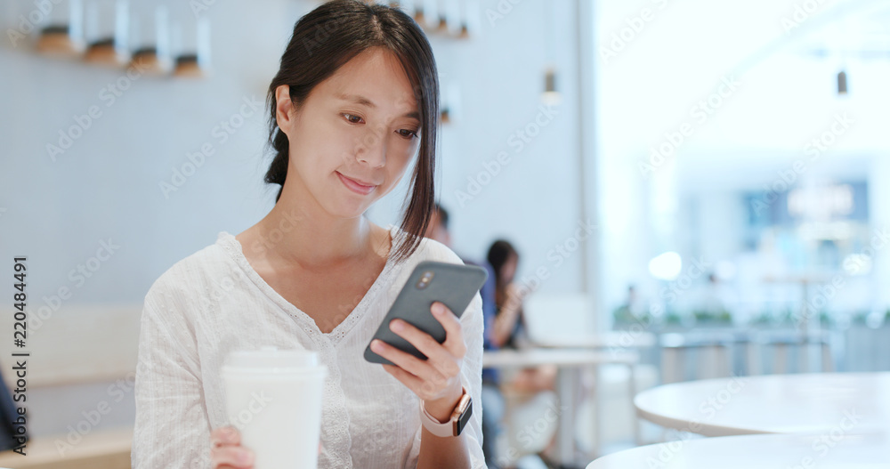 Woman use of smart phone inside coffee shop