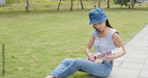 Woman playing ukulele at city