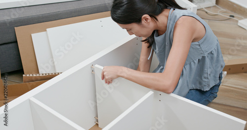  Woman assembling a shelf at home