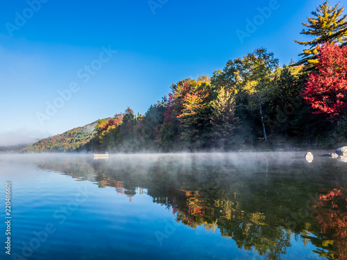 Fototapeta Naklejka Na Ścianę i Meble -  This is a picture of autumn leaves at Mont-Tremblant in the Laurentian plateau in Quebec, Canada. It is a lake on the outskirts of Mont-Tremblant. The surface of the water is like a mirror.