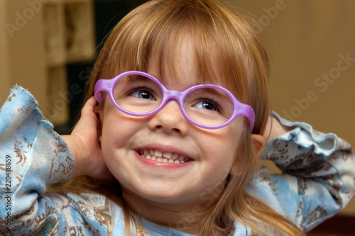 Young Girl with Strabismus Tries on New Glasses Frames On photo