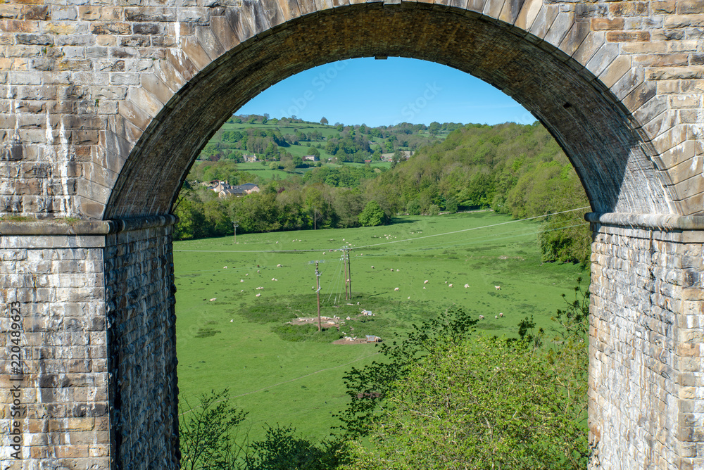 View through an arch of the Chirk railway viaduct from a narrowboat on the Chirk Aquaduct. The later built Railway viaduct runs alongside the navigable aquaduct.