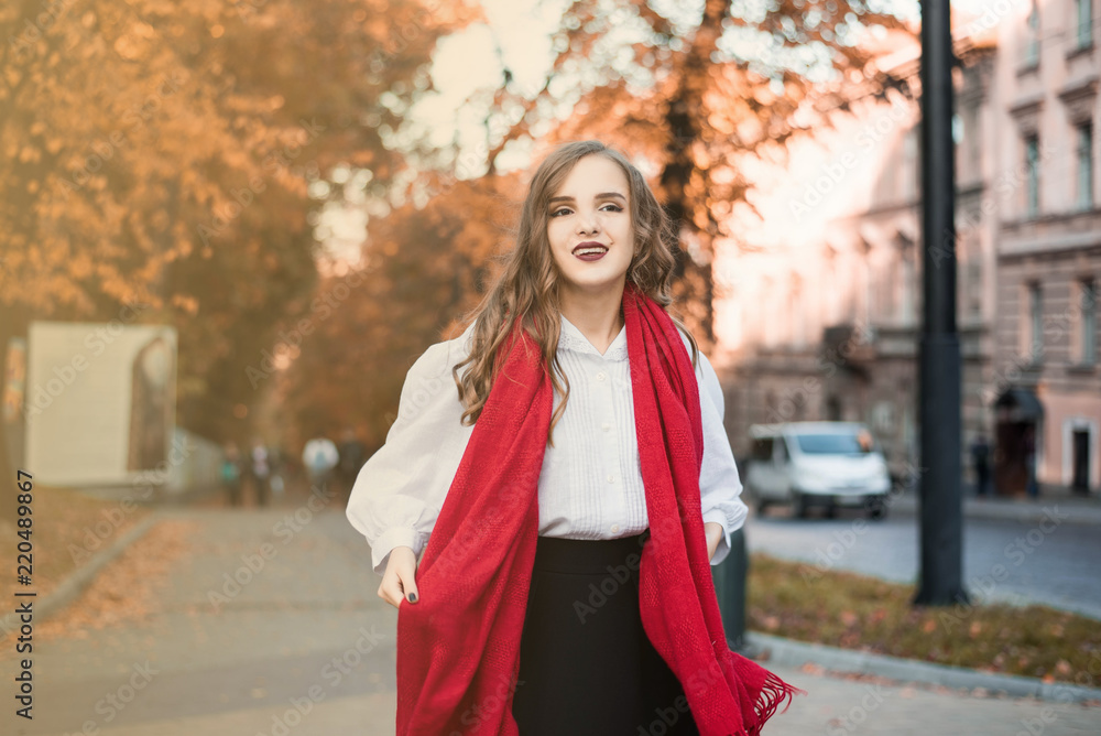 Street portrait of young beautiful woman wearing stylish classic clothes. Model looking up. Female fashion concept. French style. Parisian woman in old fashioned red scarf.