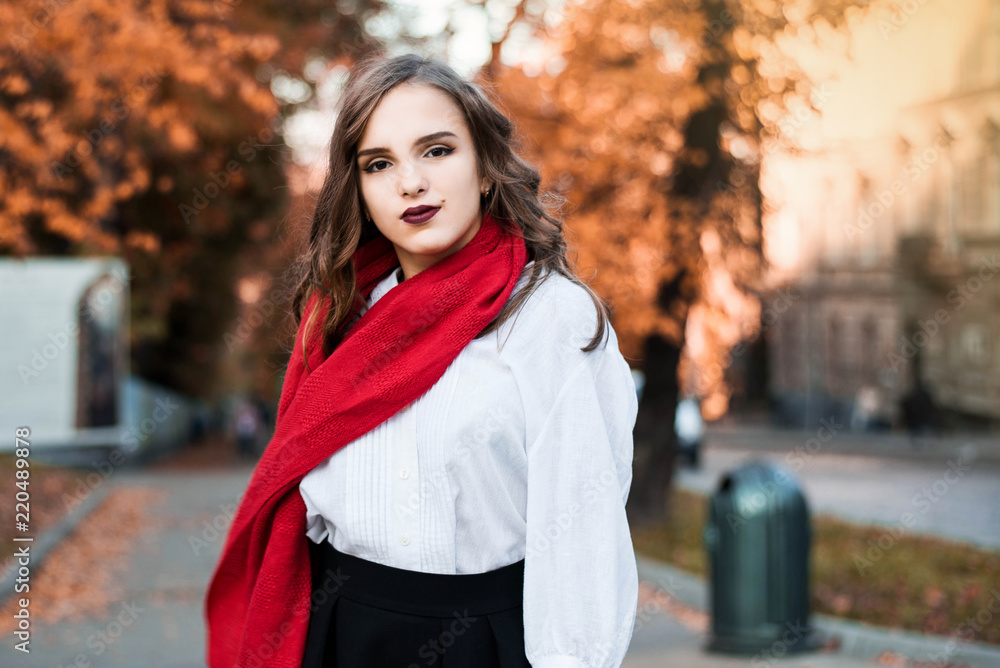 Street portrait of young beautiful woman wearing stylish classic clothes. Model looking up. Female fashion concept. French style. Parisian woman in old fashioned red scarf.