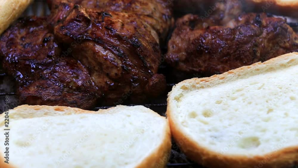 Baking bread and fresh meat on grill closeup Baking bread and fresh meat on grill closeup