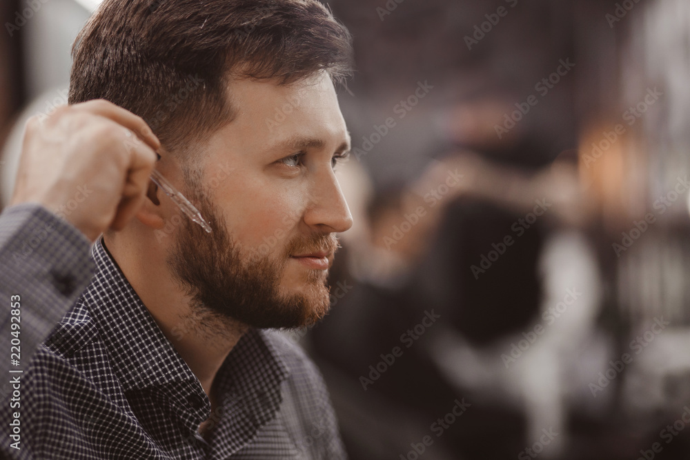 Portrait of man with beard and pipette oil for hair care. Concept Barbershop Portrait of man with beard and pipette oil for hair care. Concept Barbershop