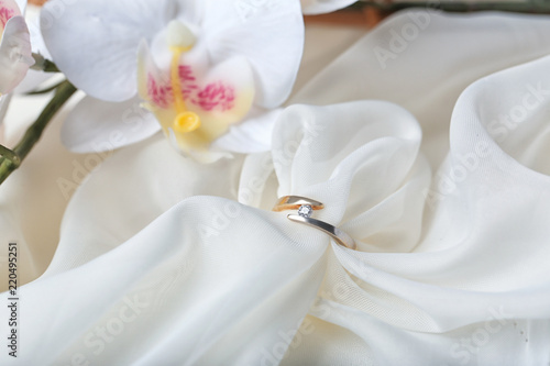 Fototapeta Naklejka Na Ścianę i Meble -  Beautiful engagement ring on light fabric, closeup
