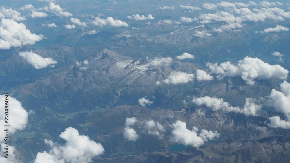 Flying over the European Alps during summer season. Aerial view from the airplane window Flying over the European Alps during summer season. Aerial view from the airplane window
