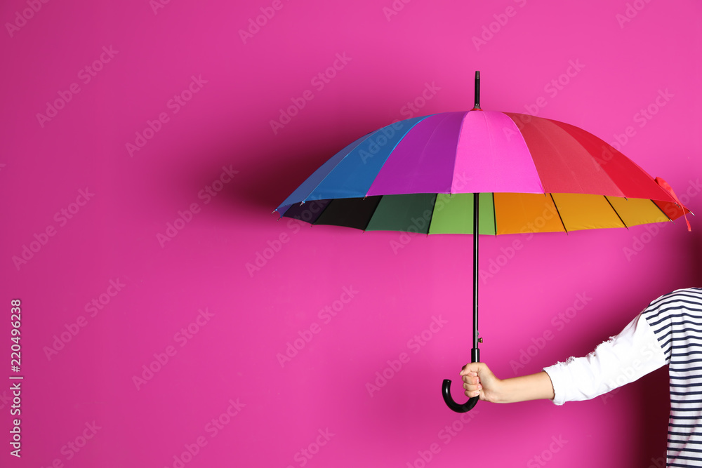 Obraz premium Woman holding beautiful umbrella on color background with space for design