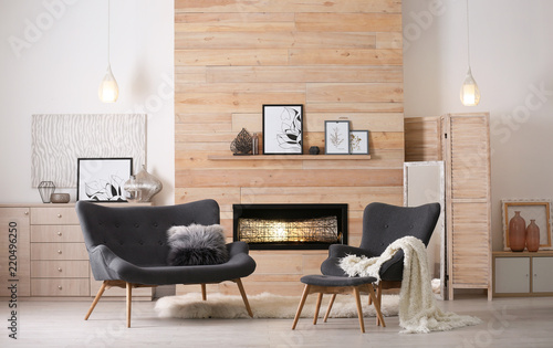 Cozy living room interior with comfortable furniture and decorative fireplace photo