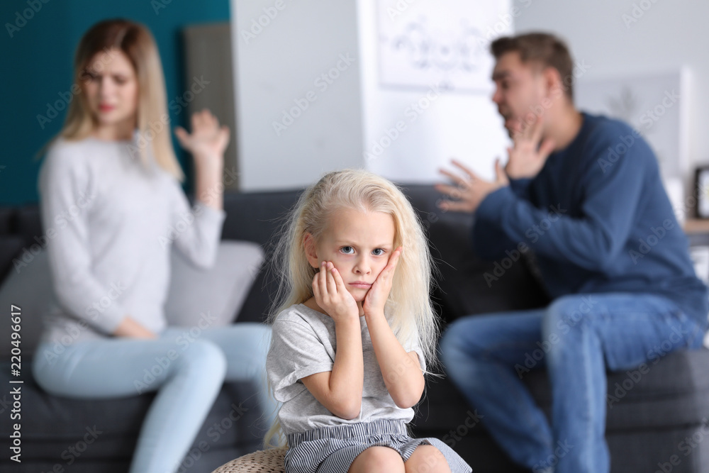 Sad little girl in room with quarreling parents. Family conflict Sad little girl in room with quarreling parents. Family conflict