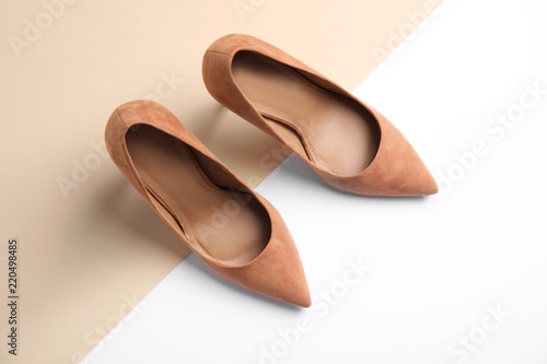 Pair of beautiful shoes on color background, top view