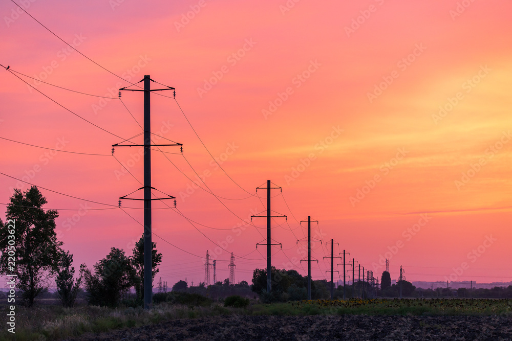 Rural landscape with high-voltage line on sunset