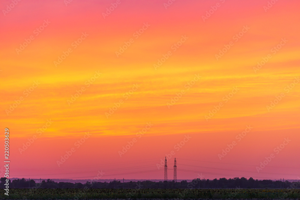 Rural landscape with high-voltage line on sunset